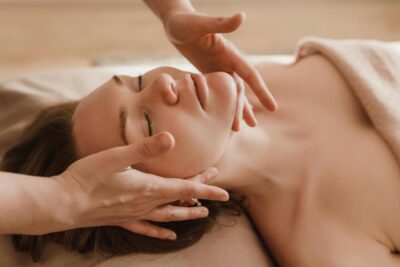 Woman relaxing during facial massage treatment