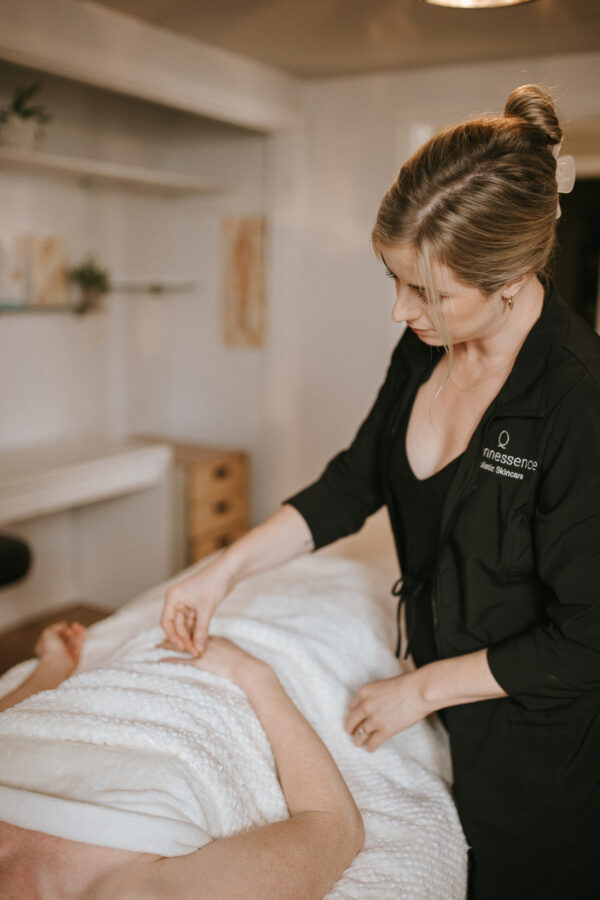 Emma administering acupuncture treatment to client's hand