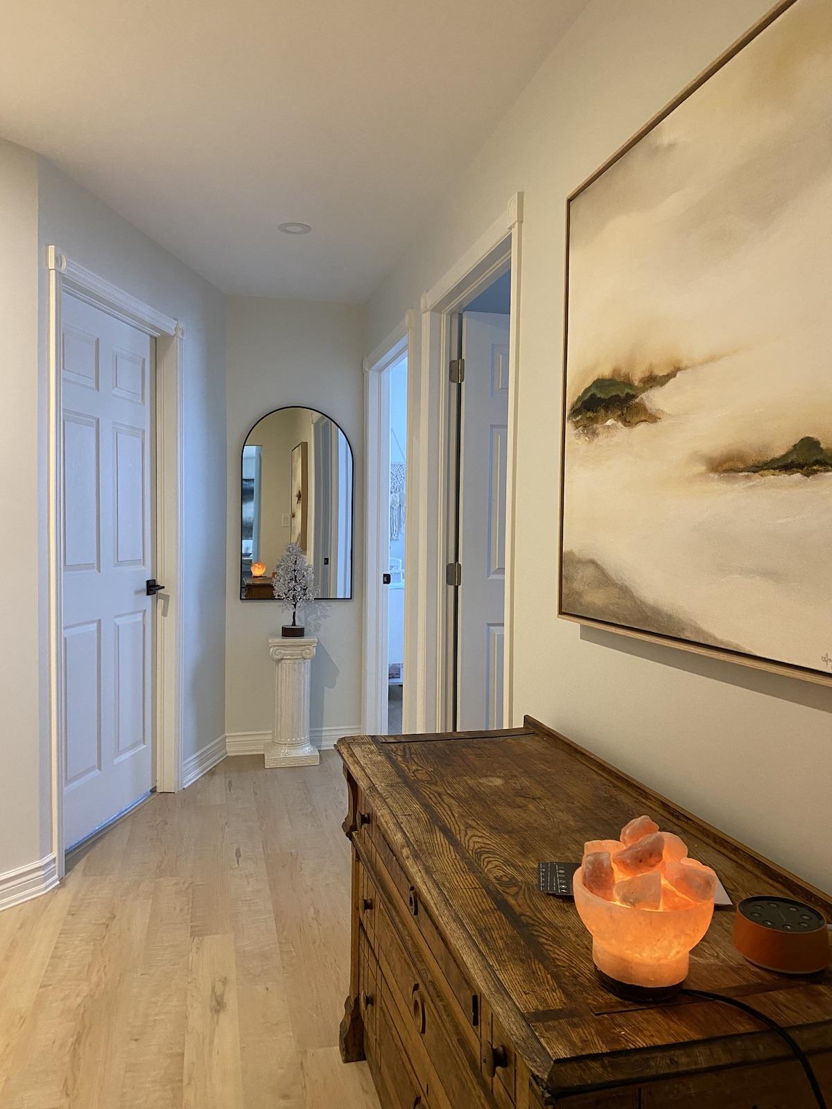 Hallway in QuannSpa with antique cabinet, scenic artowkr and Himalayan salt lamp