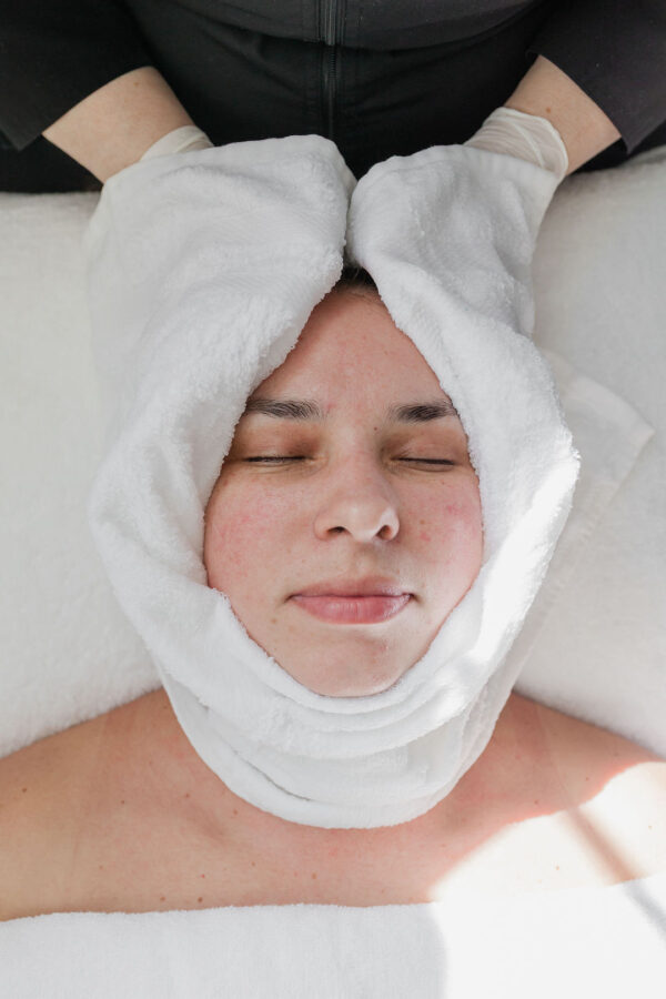 Woman relaxed with eyes closed after facial treatment