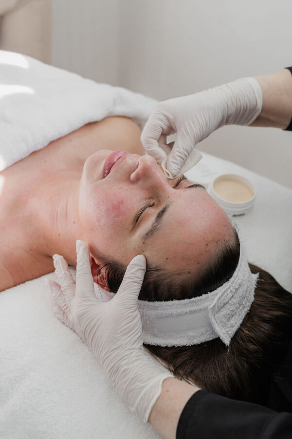 Woman relaxed with eyes closed during facial treatment