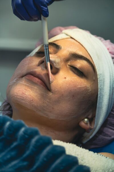 Close-up of a woman receiving a brush-on facial treatment.